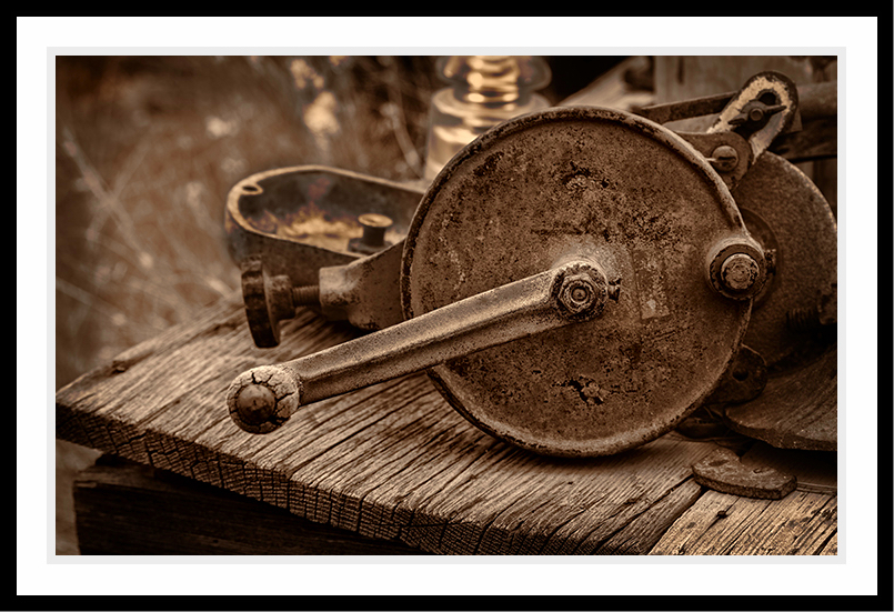 An old crank (in sepia) sitting on a table.